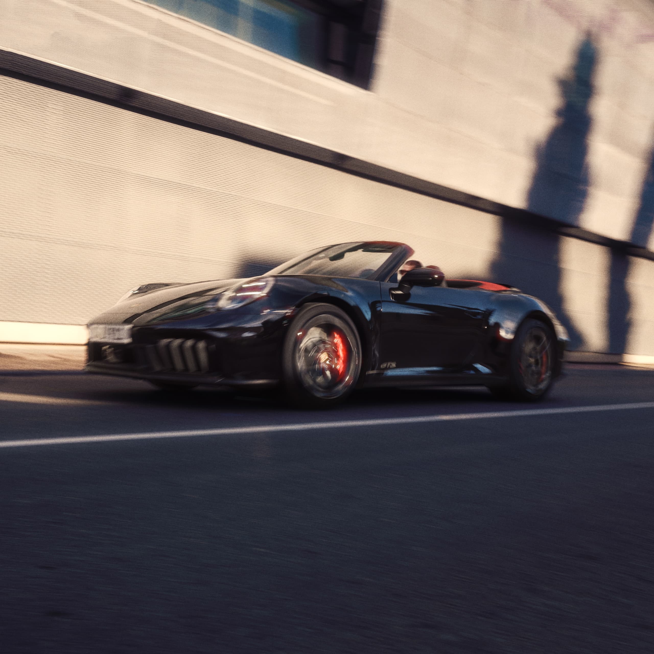 En Porsche 911 kjører nedover en vei.